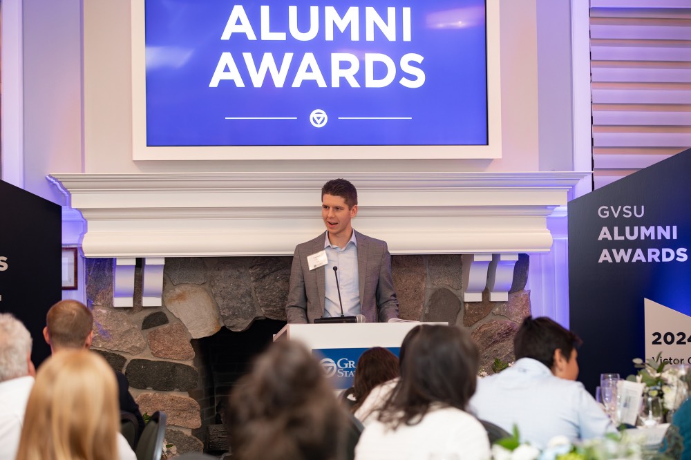 Man looking towards the left as he speaks into microphone